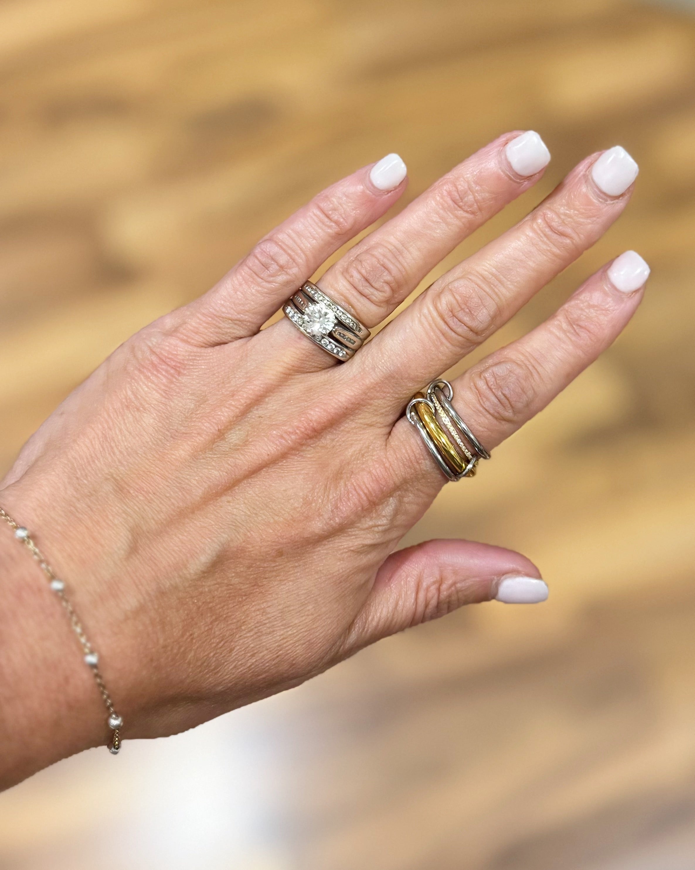 Hand with multiple rings on a blurred natural background