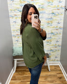 woman wearing a olive 3/4 sleeve flowy top.