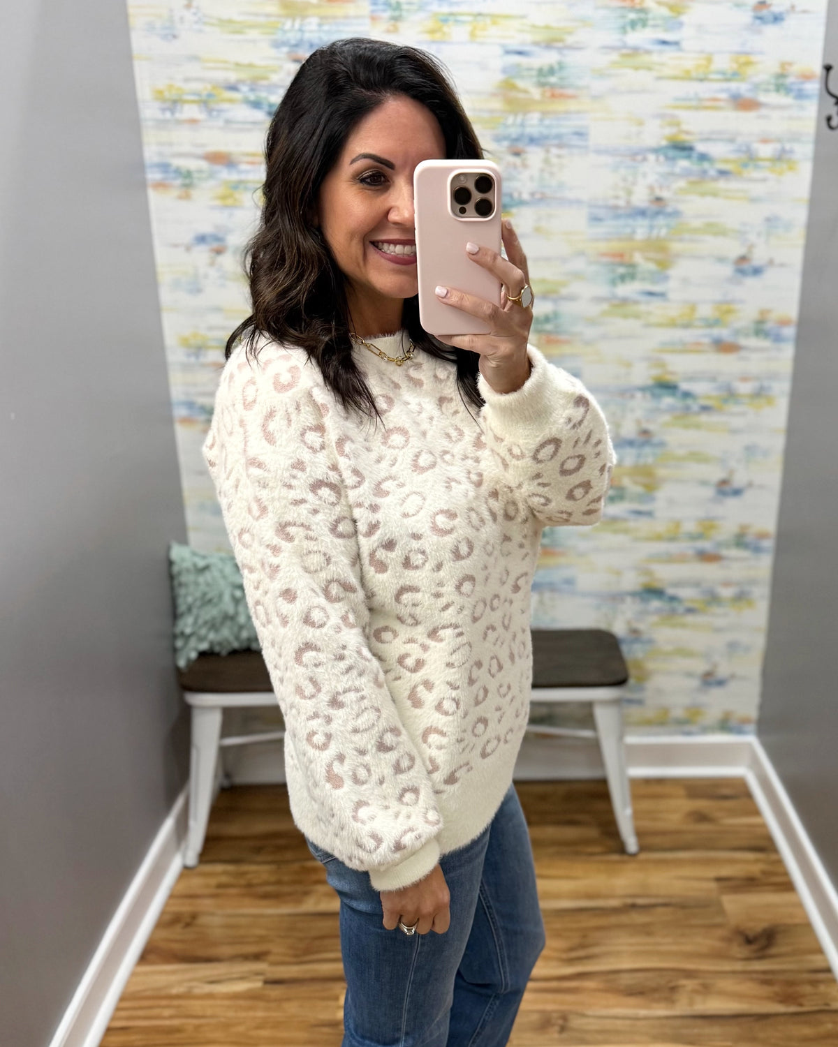 woman taking a selfie wearing a super soft cream sweater with subtle leopard print design. 