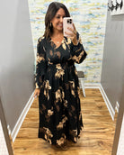 woman wearing a black maxi dress with brown and taupe floral pattern. 