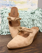 Corkys Oh Bow She Didn't Mule in camel faux suede is a chic slip-on shoe featuring a 2.5" wood grain block hell and a playful knotted bow detail