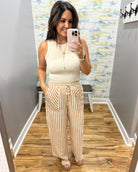 woman wearing stripe pants and taupe tank.