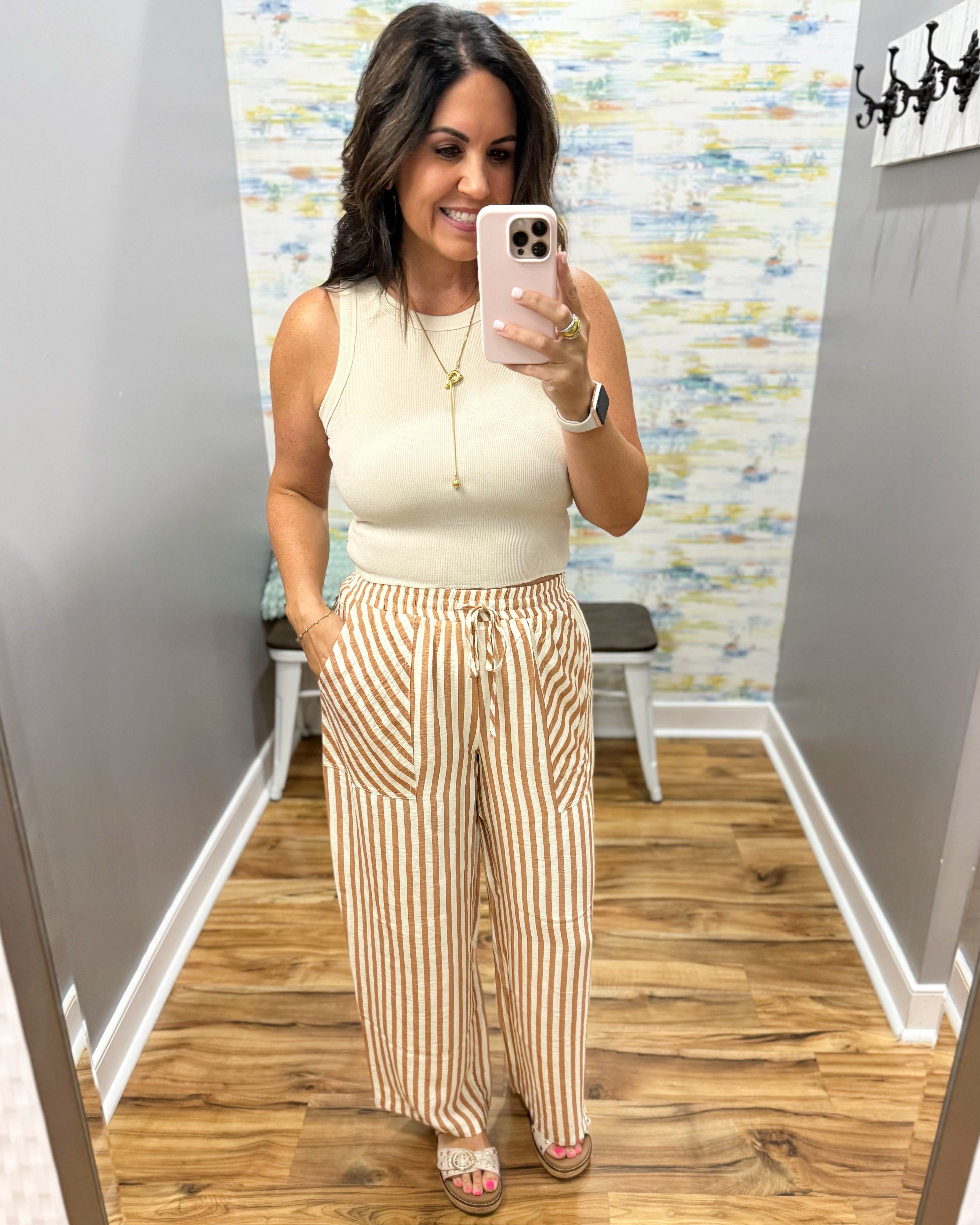 woman wearing stripe pants and taupe tank.