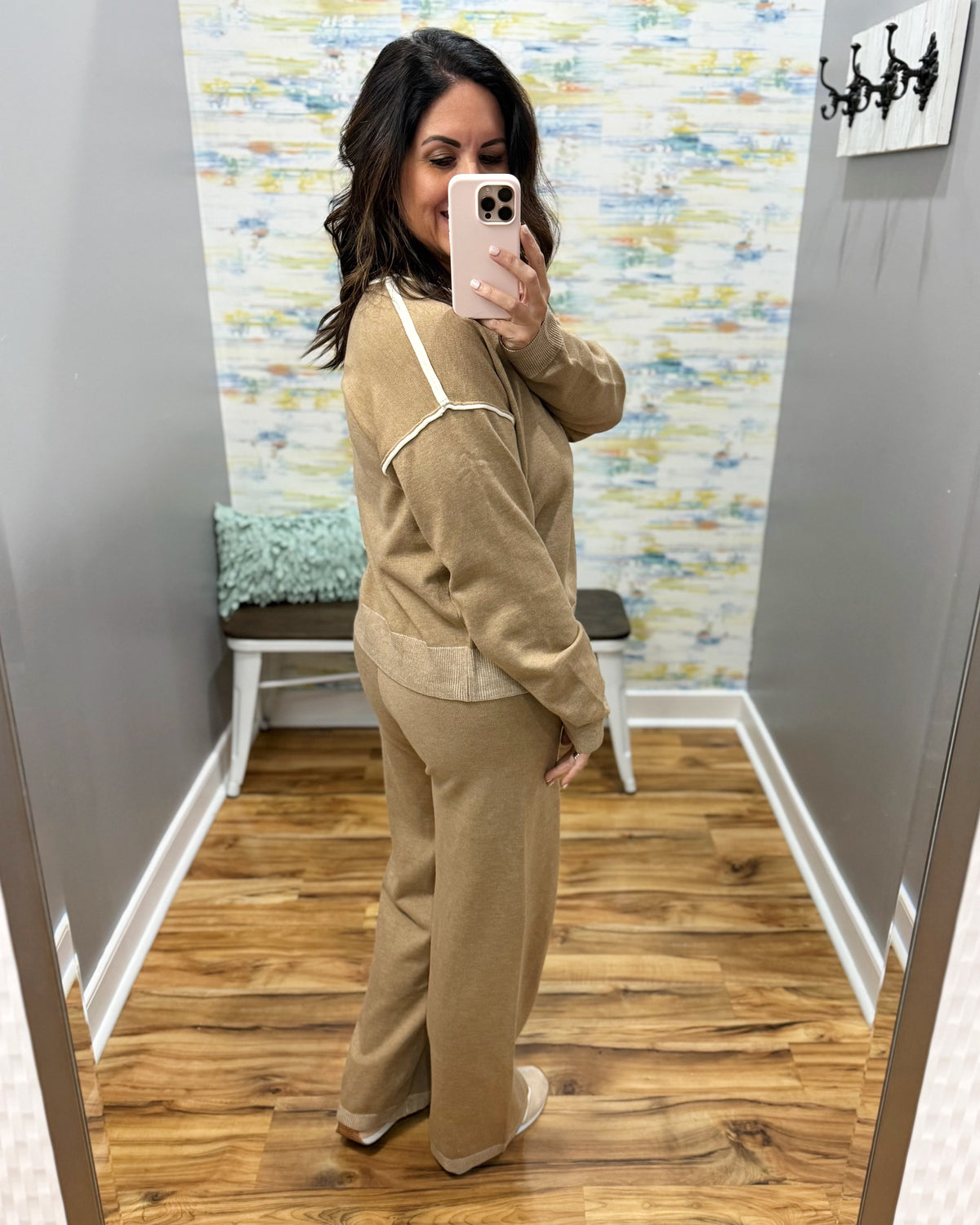woman taking a selfie wearing a two-piece set in mocha with cream pipe stitching.  Set includes pants and long sleeve top.