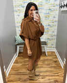 woman taking a selfie wearing a camel color wrap dress featuring a V-neckline, cinched waist, and flowy short sleeves for a feminine silhouette.