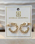 Gold chain earrings on a Michelle McDowell branded card.