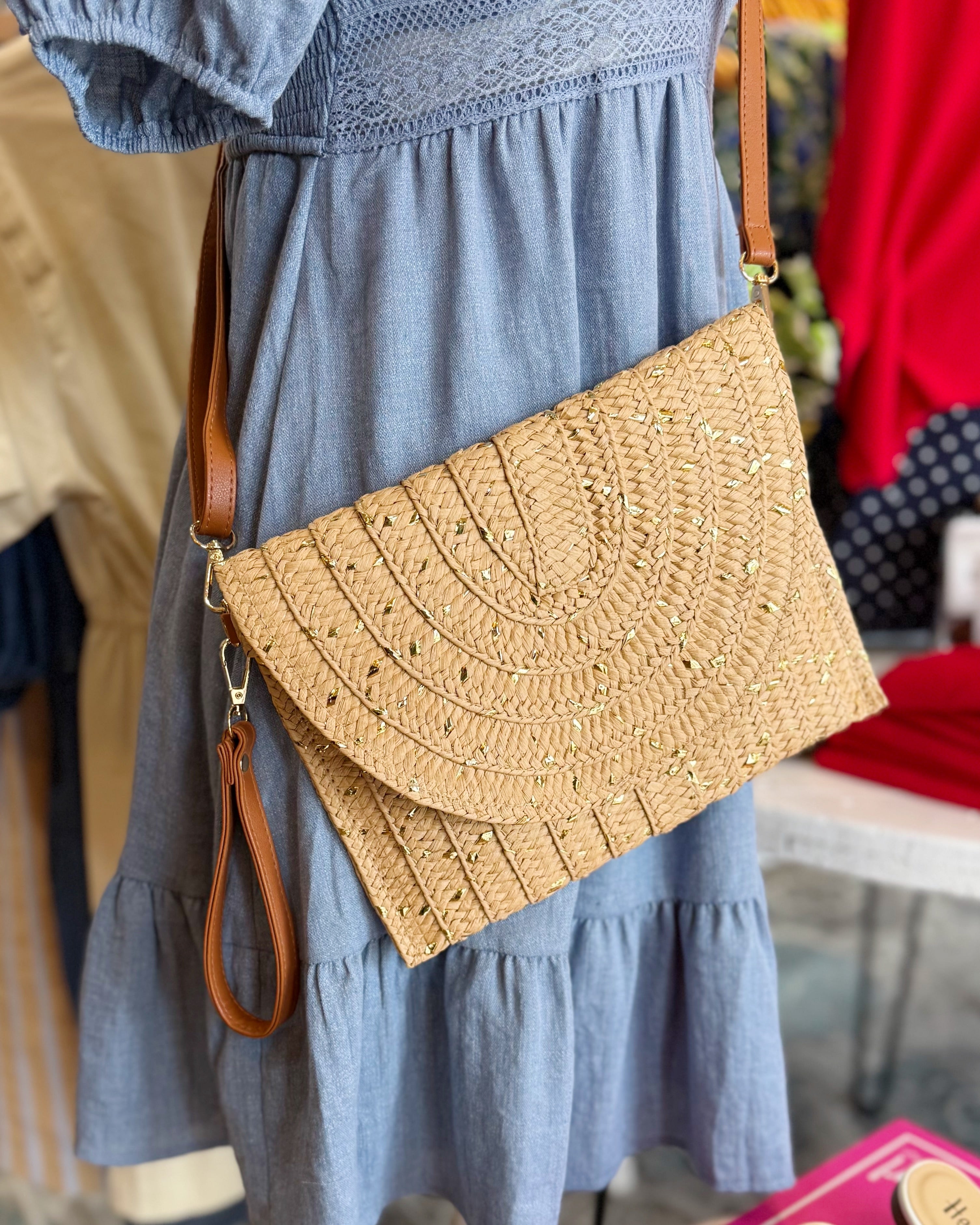 Person wearing a blue dress with a straw handbag in an indoor setting