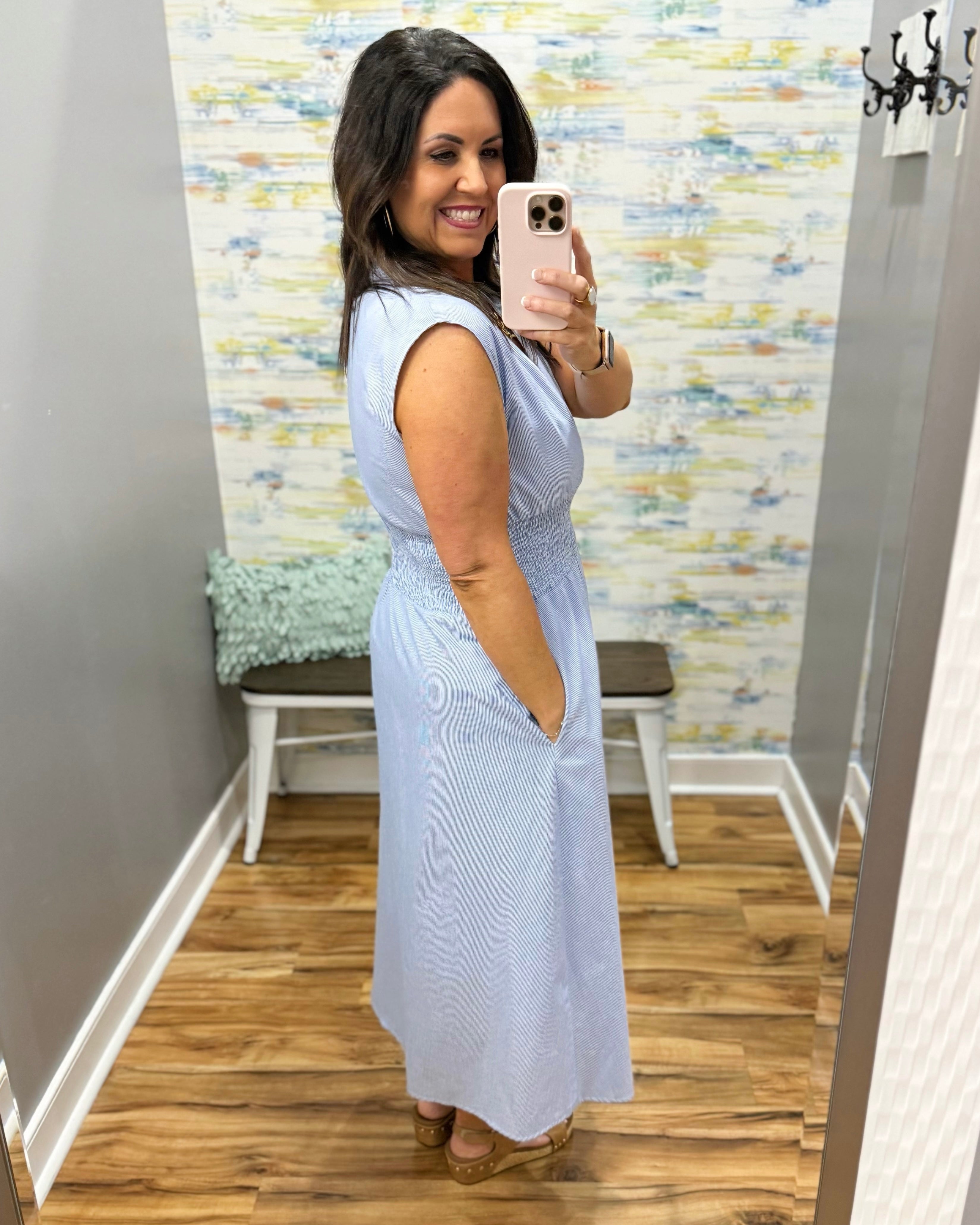 Woman wearing a light blue dress in a fitting room.