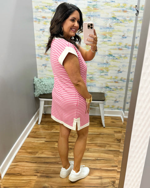 woman wearing pink and white stripe dress with white sneakers