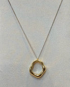 This two tone open ring pendant necklace features a sculpted organic wavy ring in polished gold tone hanging from a silver tone curb chain with a lobster clasp.