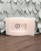 White electronic device with 'Teleties' logo on a textured surface