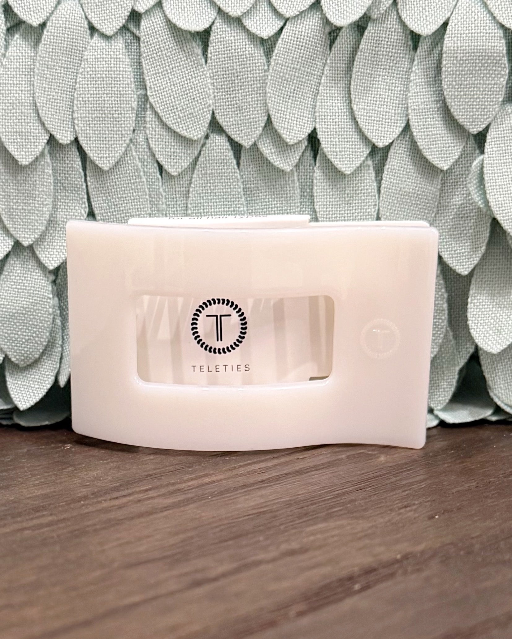 White electronic device with 'Teleties' logo on a textured surface