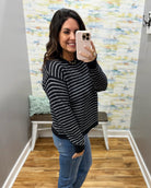 woman taking a selfie wearing a navy and white stripe sweater.