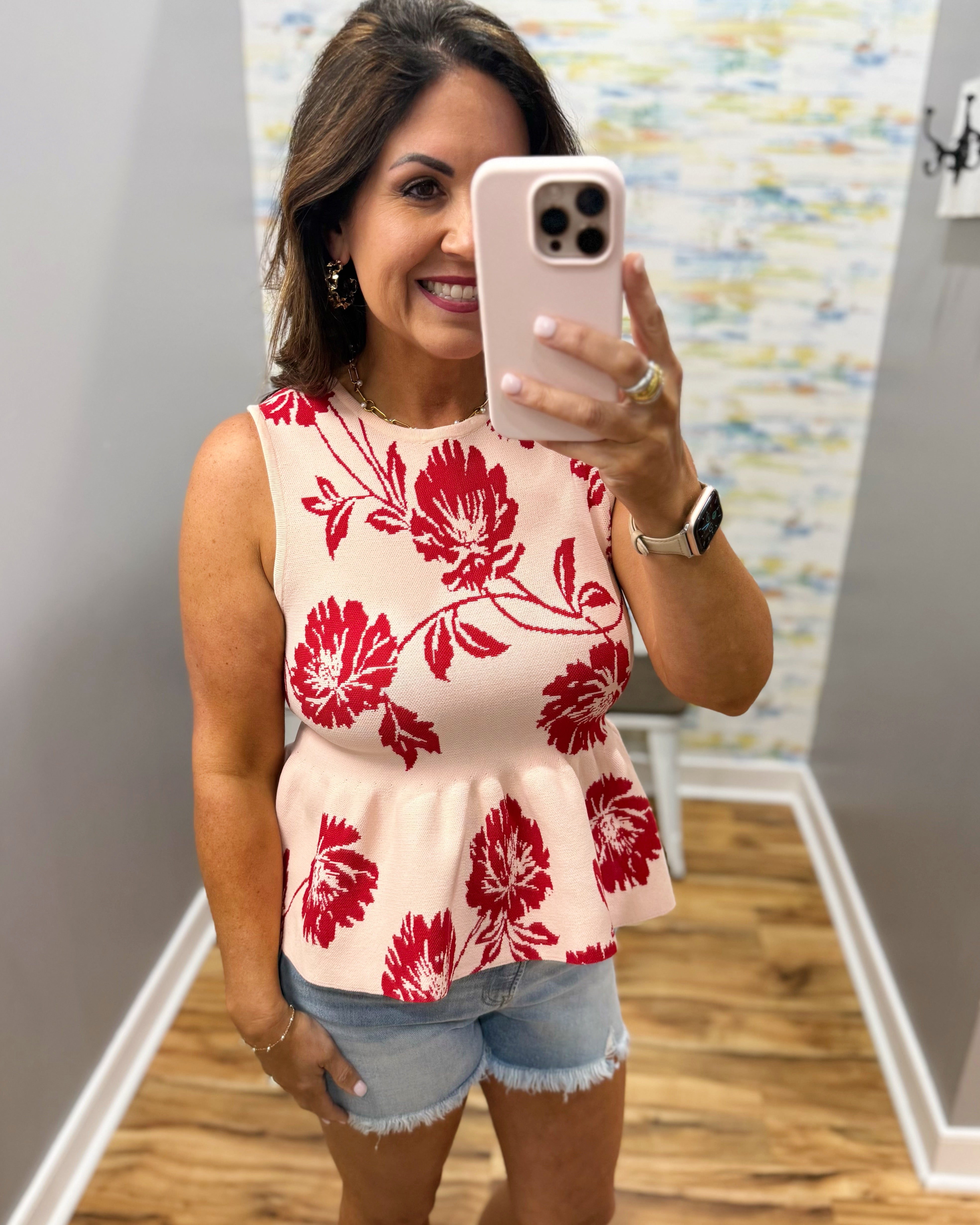 woman wearing a floral sweater tank. 