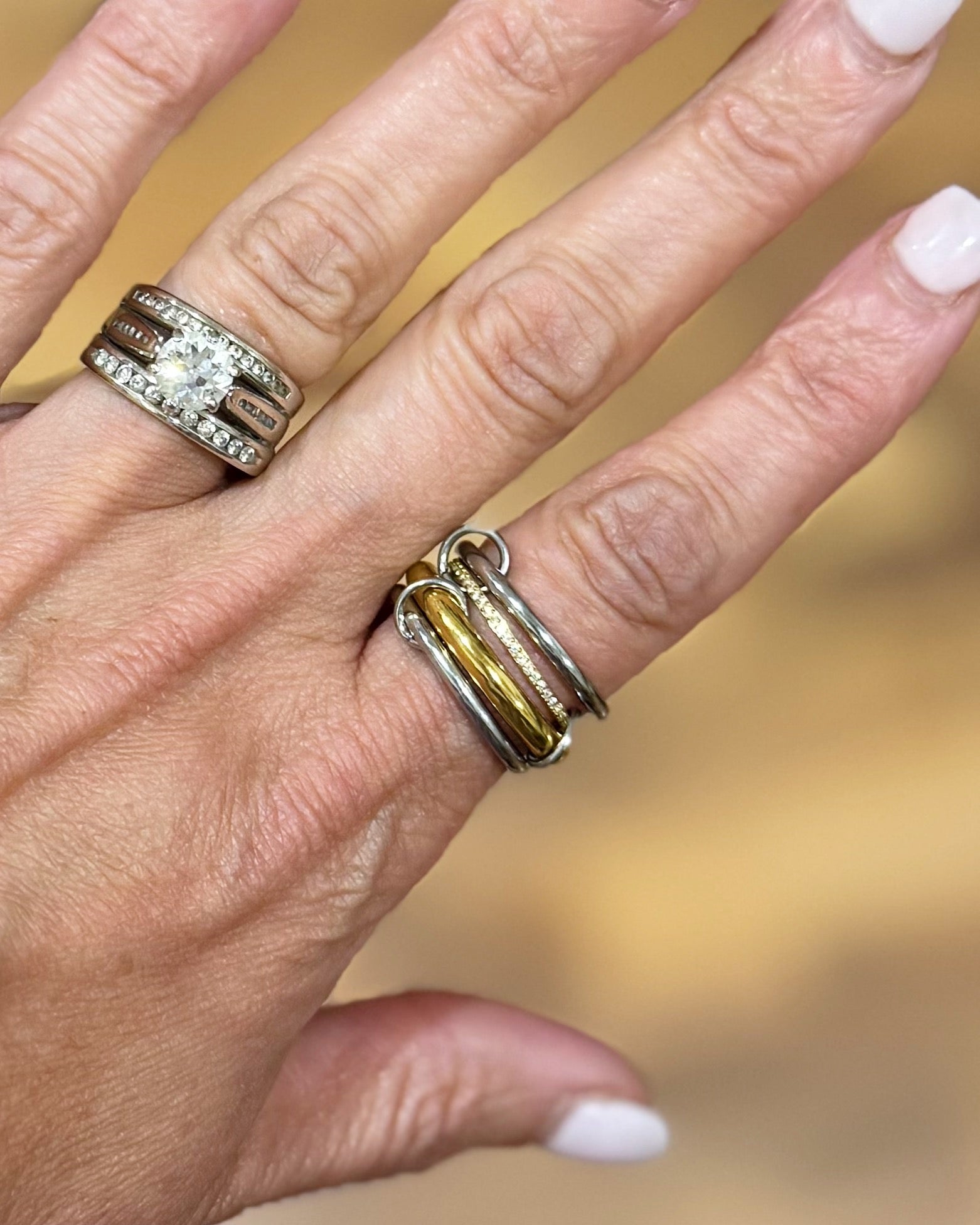 Hand wearing two rings with a blurred background