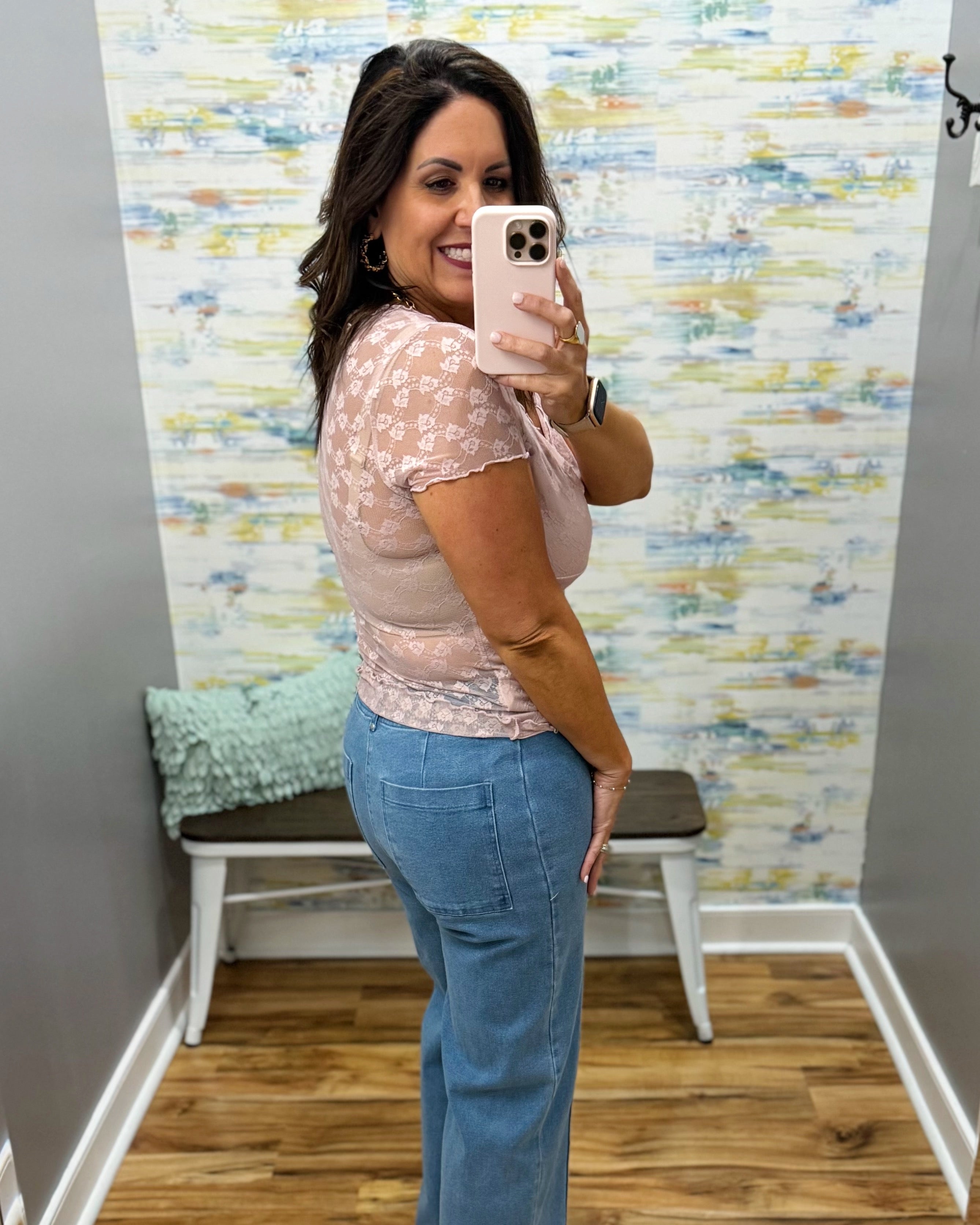 woman wearing a lilac colored top with denim wide leg pants.