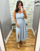 woman wearing a light blue denim maxi dress.