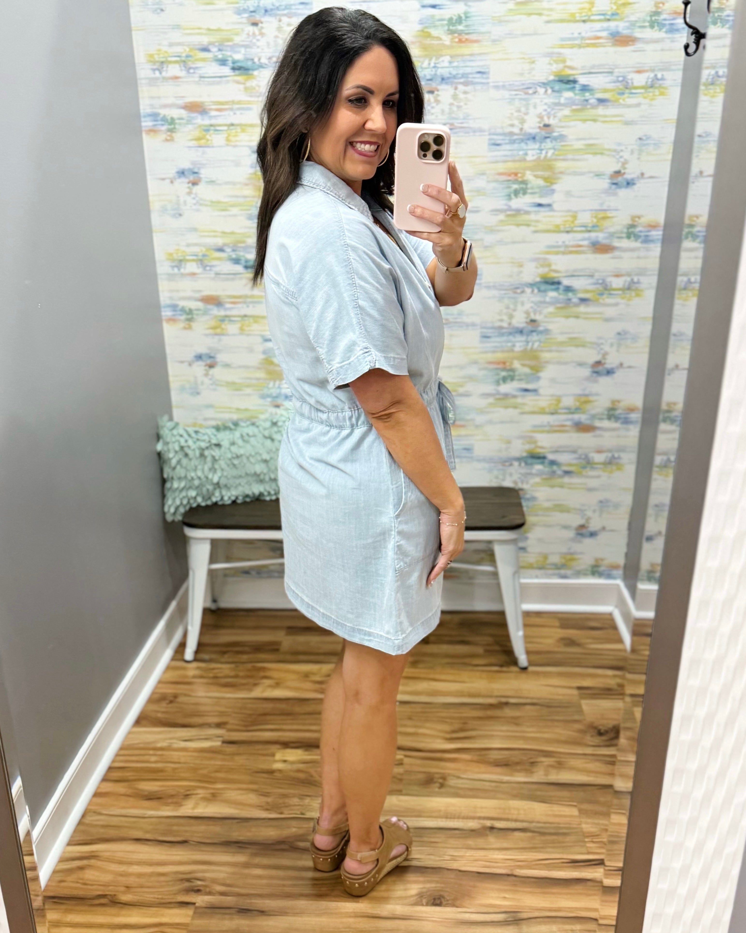 Woman wearing a light blue dress in a room with a colorful wall.