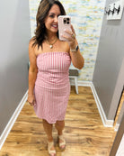 woman wearing a strapless red and white stripe dress.