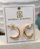 Gold hoop earrings on a Michelle McDowell branded card.