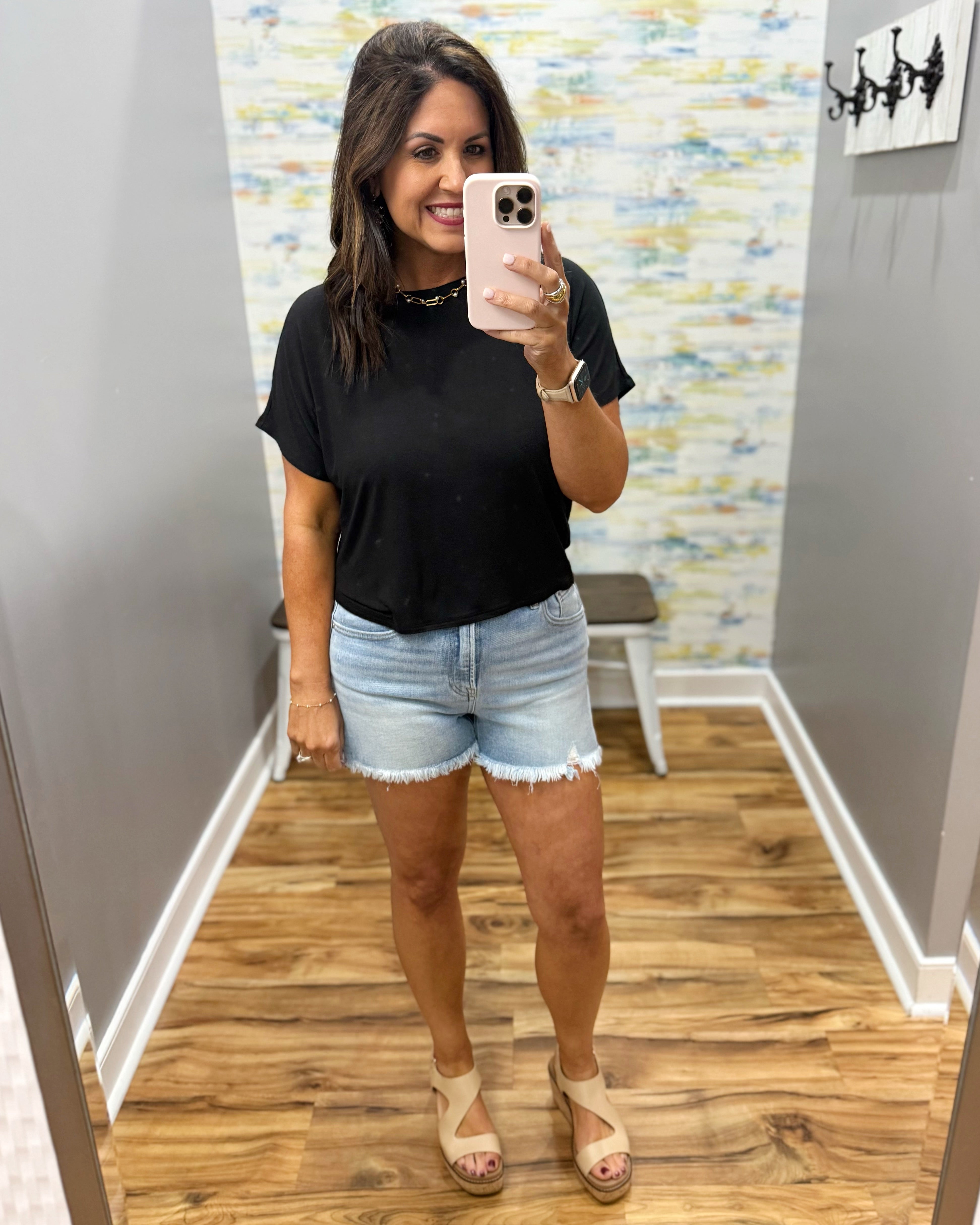 woman wearing black tee with denim shorts.