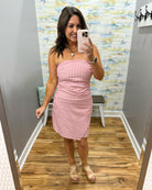 woman wearing a strapless red and white stripe dress.