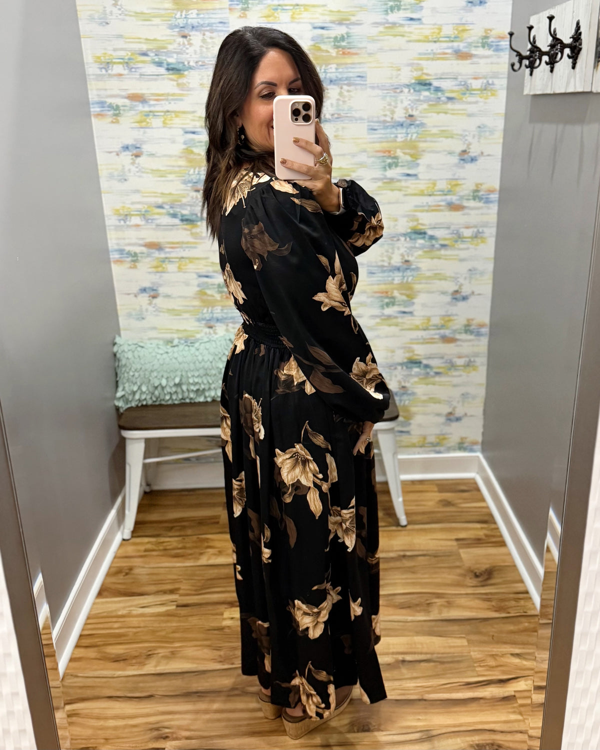 woman wearing a black maxi dress with brown and taupe floral pattern. 