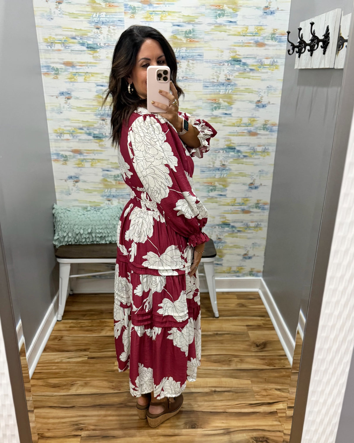 woman taking a selfie in a floral midi dress in berry color. 