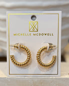 Gold hoop earrings on a Michelle McDowell branded card.