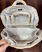 An open taupe color patterned organizer bag with multiple interior compartments, shown on a dark wooden surface.
