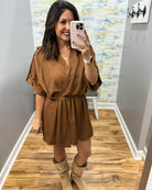 woman taking a selfie wearing a camel color wrap dress featuring a V-neckline, cinched waist, and flowy short sleeves for a feminine silhouette.
