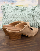 Corkys Oh Bow She Didn't Mule in camel faux suede is a chic slip-on shoe featuring a 2.5" wood grain block hell and a playful knotted bow detail