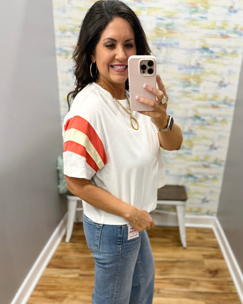woman wearing white tee with colorful sleeves and chunky gold necklace