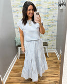 Woman wearing a striped outfit in a store.