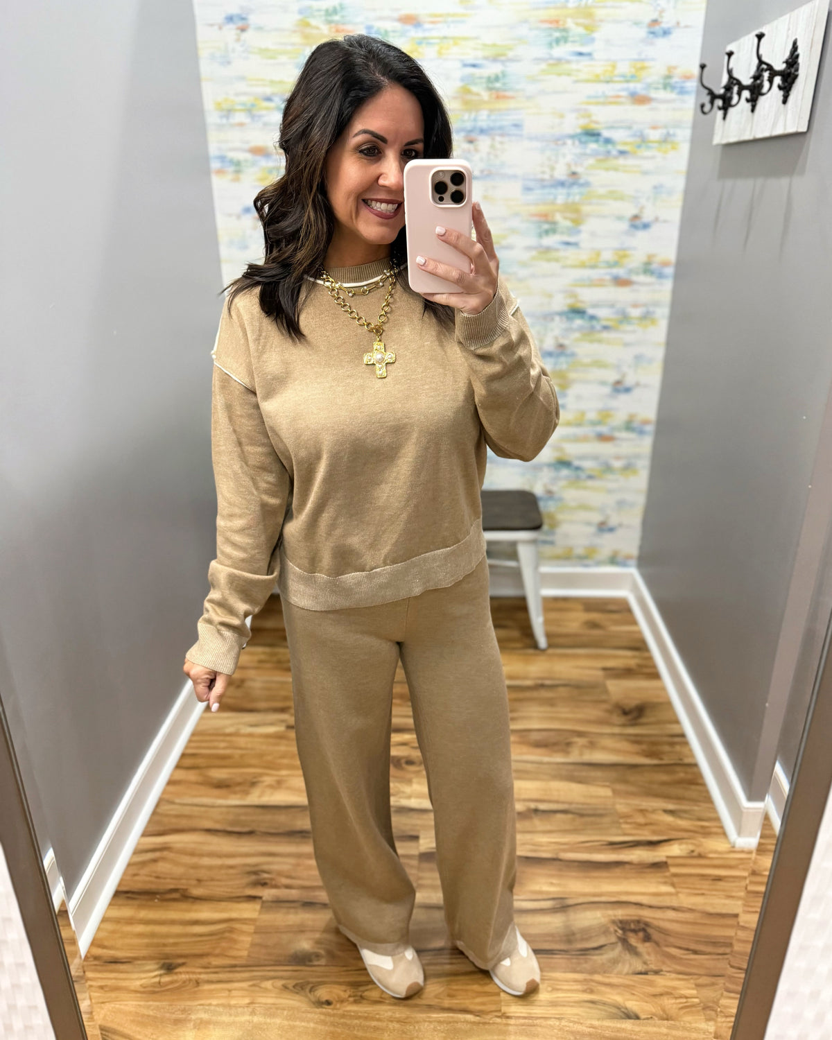 woman taking a selfie wearing a two-piece set in mocha with cream pipe stitching.  Set includes pants and long sleeve top.