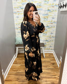 woman wearing a black maxi dress with brown and taupe floral pattern. 