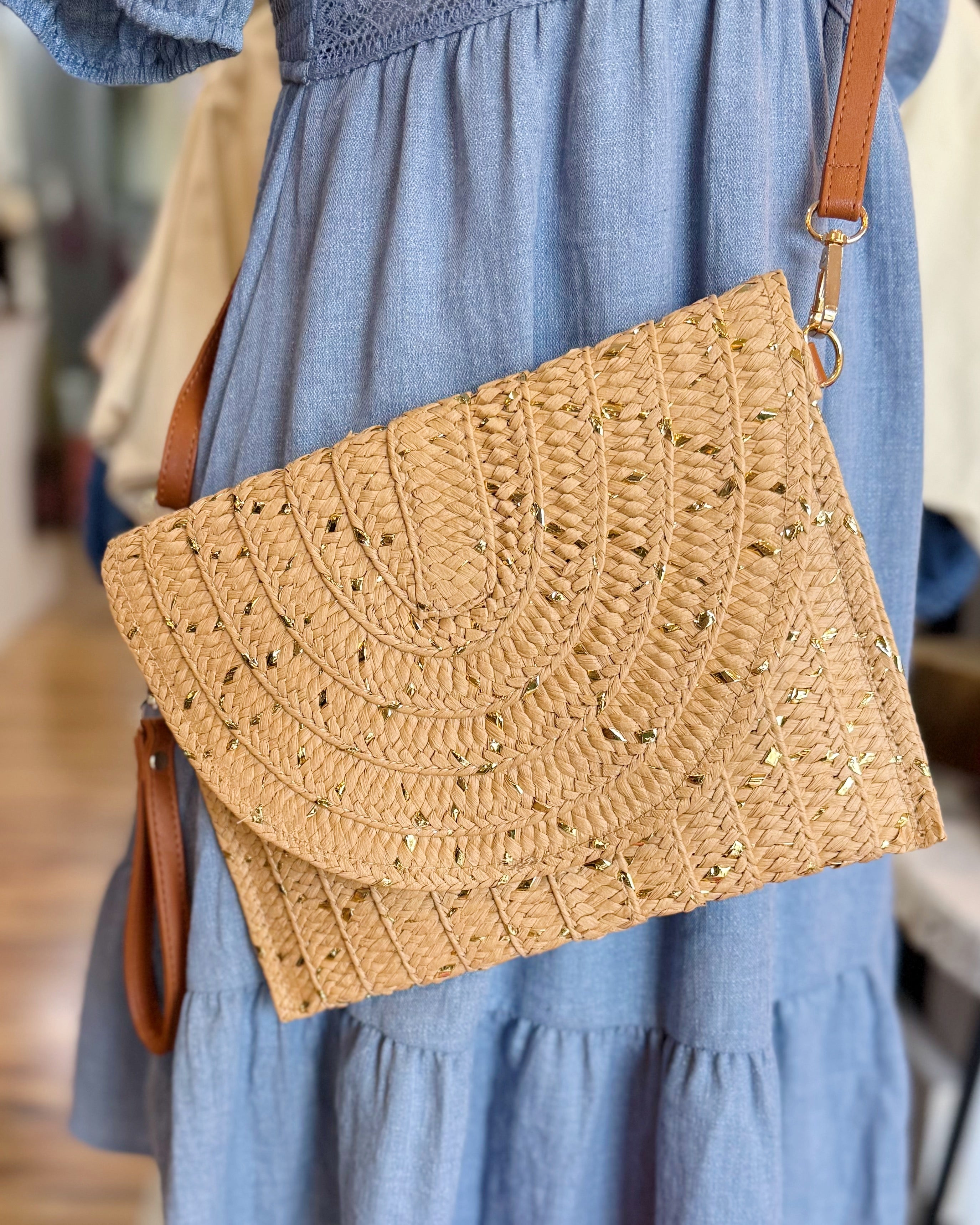 Woven handbag held by a person wearing a blue dress