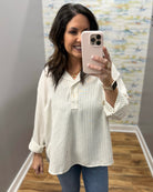 woman wearing a stripe blouse in mocha and white.
