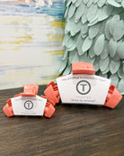 Teleties hair clips on a wooden surface with a colorful abstract painting in the background