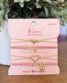 Kilani hair tie and bracelet set on a pink card with decorative elements.