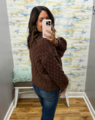 woman wearing a brown crochet sweater cardigan.