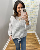 woman wearing a lightweight sweater top in stone color