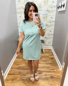 woman wearing a dark sage and white stripe dress.