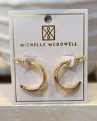 Gold hoop earrings on a Michelle McDowell branded card.
