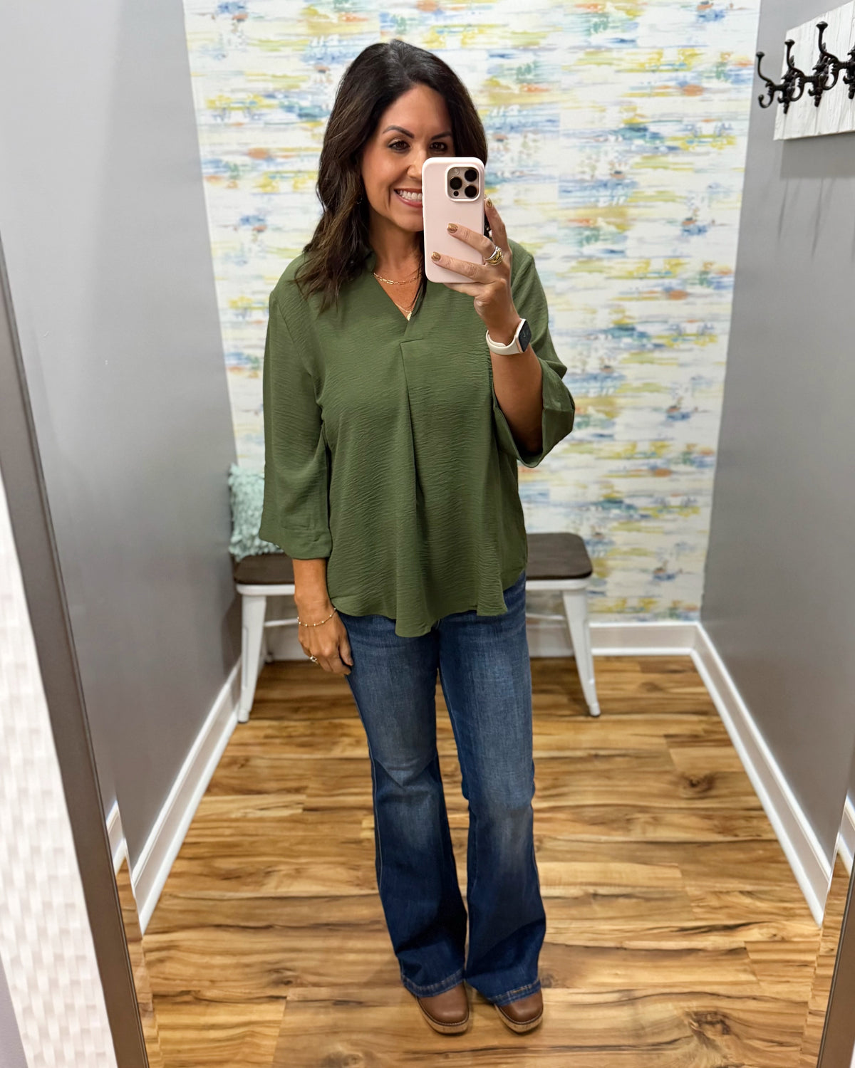 woman wearing a olive 3/4 sleeve flowy top with Judy Blue flare jeans and Corkys Pity Party wedge shoes in cognac.