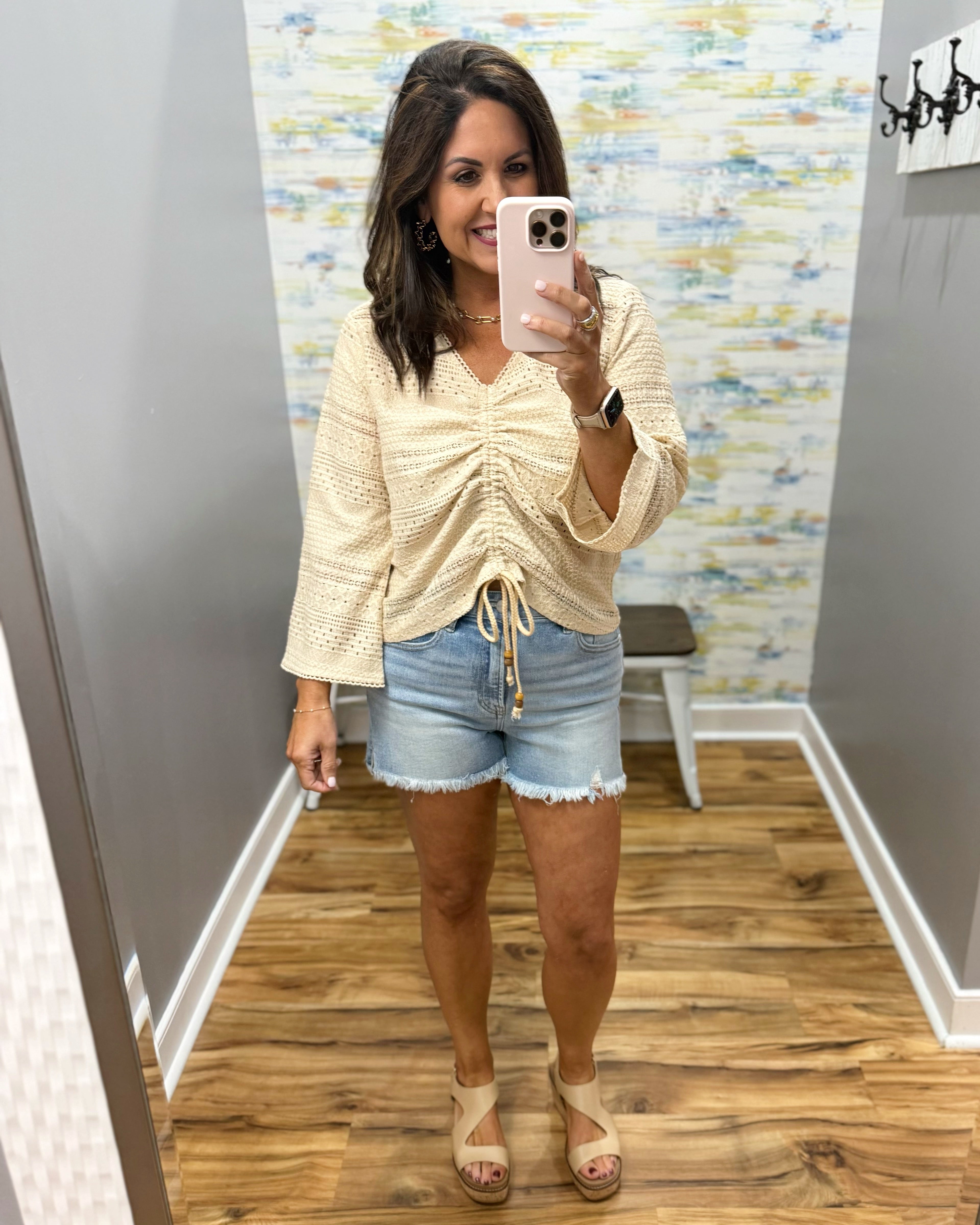 woman wearing a bell sleeve top in natural. 