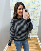 woman taking a selfie wearing a navy and white stripe sweater.