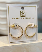 Gold hoop earrings on a Michelle McDowell branded card.
