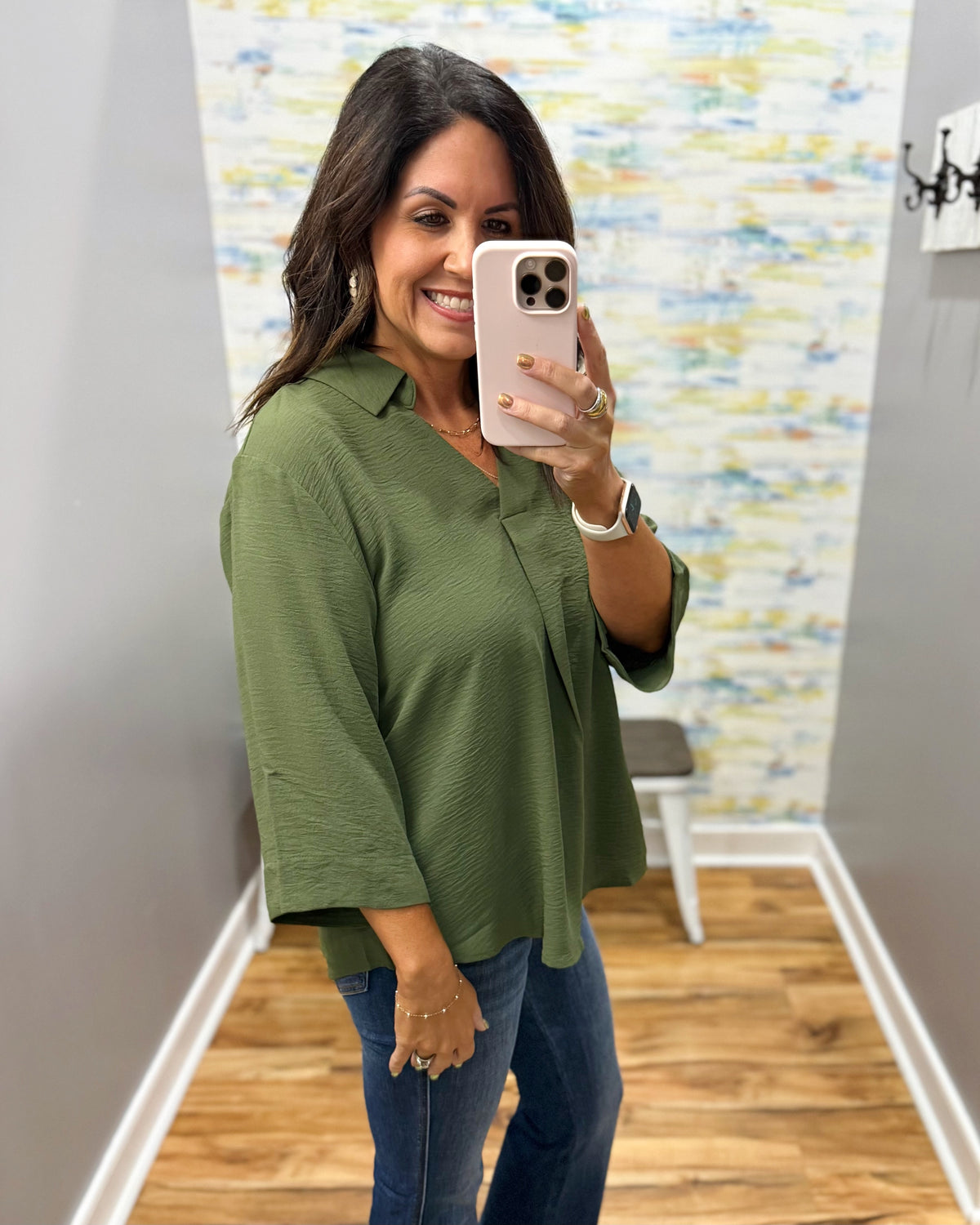 woman wearing a olive 3/4 sleeve flowy top.