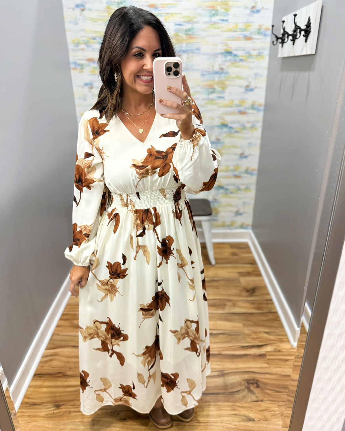 woman wearing a cream maxi dress with brown, black and taupe floral pattern. 